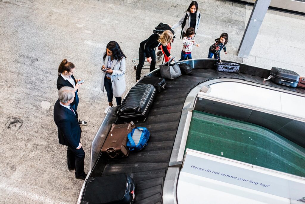 People-picking-up-their-luggage-from-baggage-carousel-at-airport_AzmanJaka.jpg