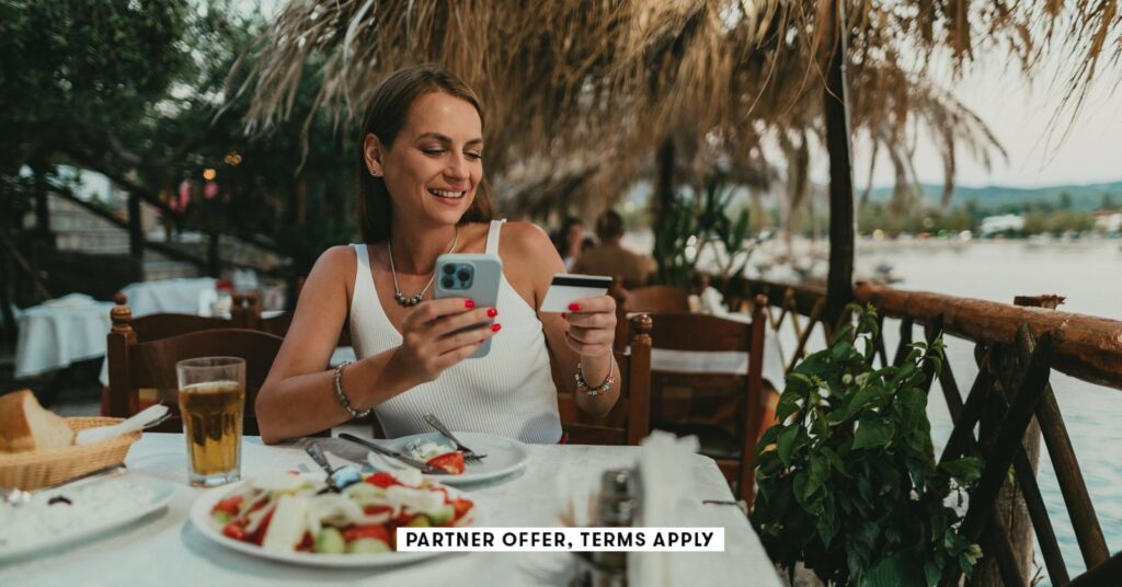 SOCIAL-IMAGE_PARTNER-OFFERS-TERMS-APPLY_Woman-using-a-smartphone-and-paying-with-a-credit-card-in-a.jpeg