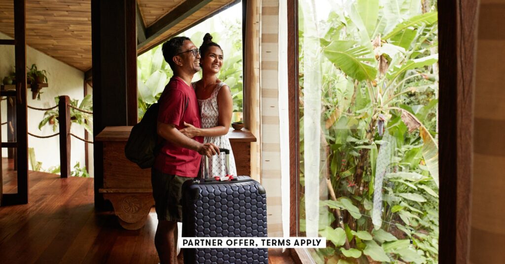 SOCIAL-IMAGE_PARTNER-OFFER-TERMS-APPLY_Couple-standing-near-window-at-villa-with-suitcase_Klaus-Vedf.jpeg