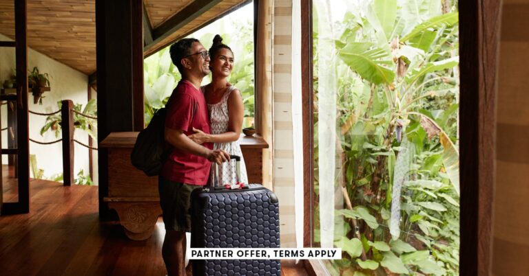 SOCIAL-IMAGE_PARTNER-OFFER-TERMS-APPLY_Couple-standing-near-window-at-villa-with-suitcase_Klaus-Vedf.jpeg