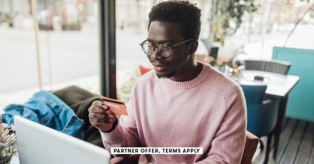SOCIAL-IMAGE_PARTNER-OFFERS-TERMS-APPLY_Man-sitting-at-cafe-using-laptop-and-holding-credit-card_Mix.jpeg