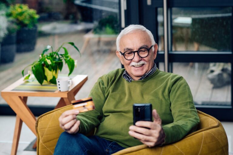Senior-mna-using-credit-card-for-shopping-on-smart-phone-at-home_MixMedia.jpg